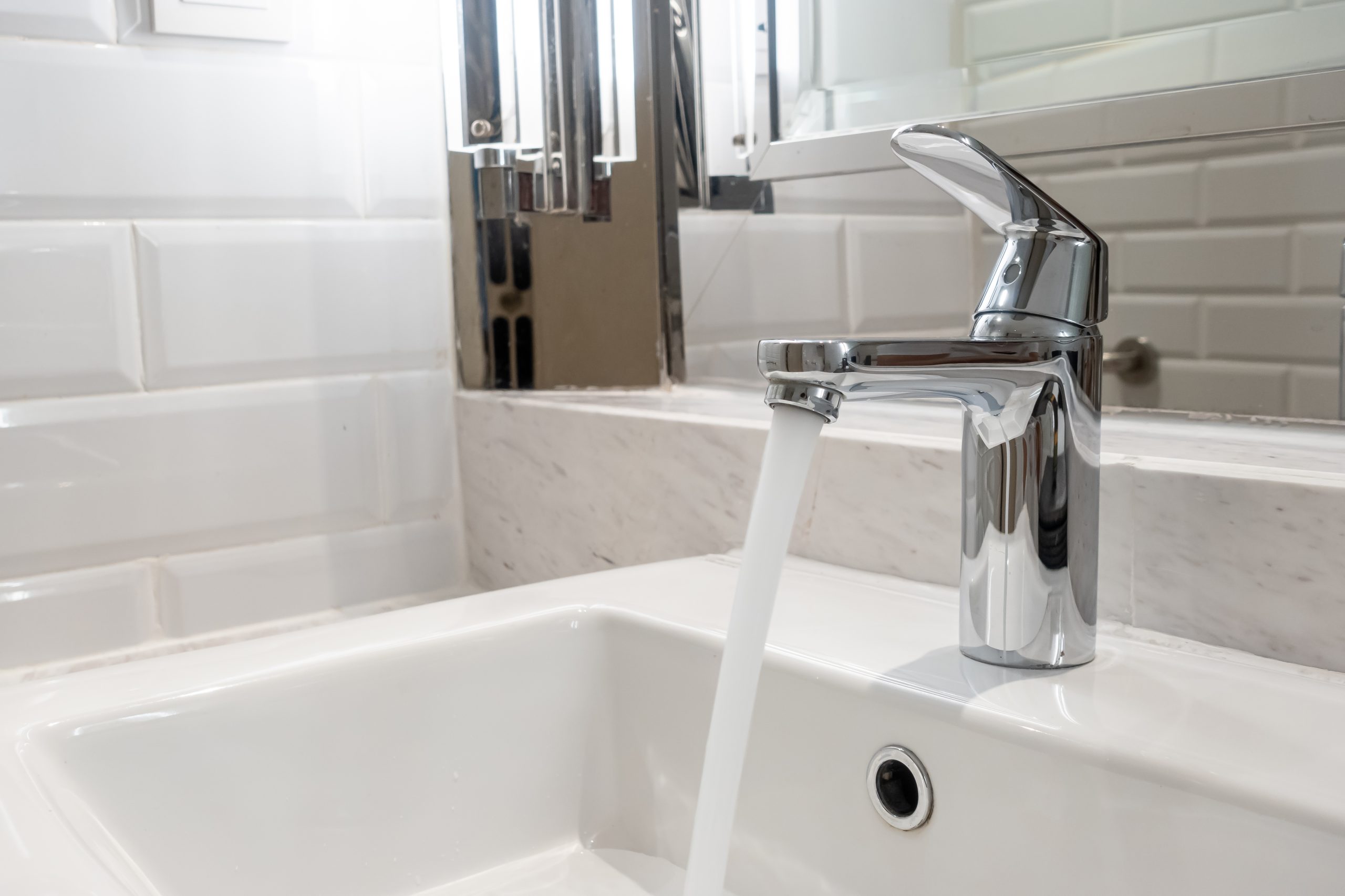 Plumber fixing a leaky faucet in a residential kitchen